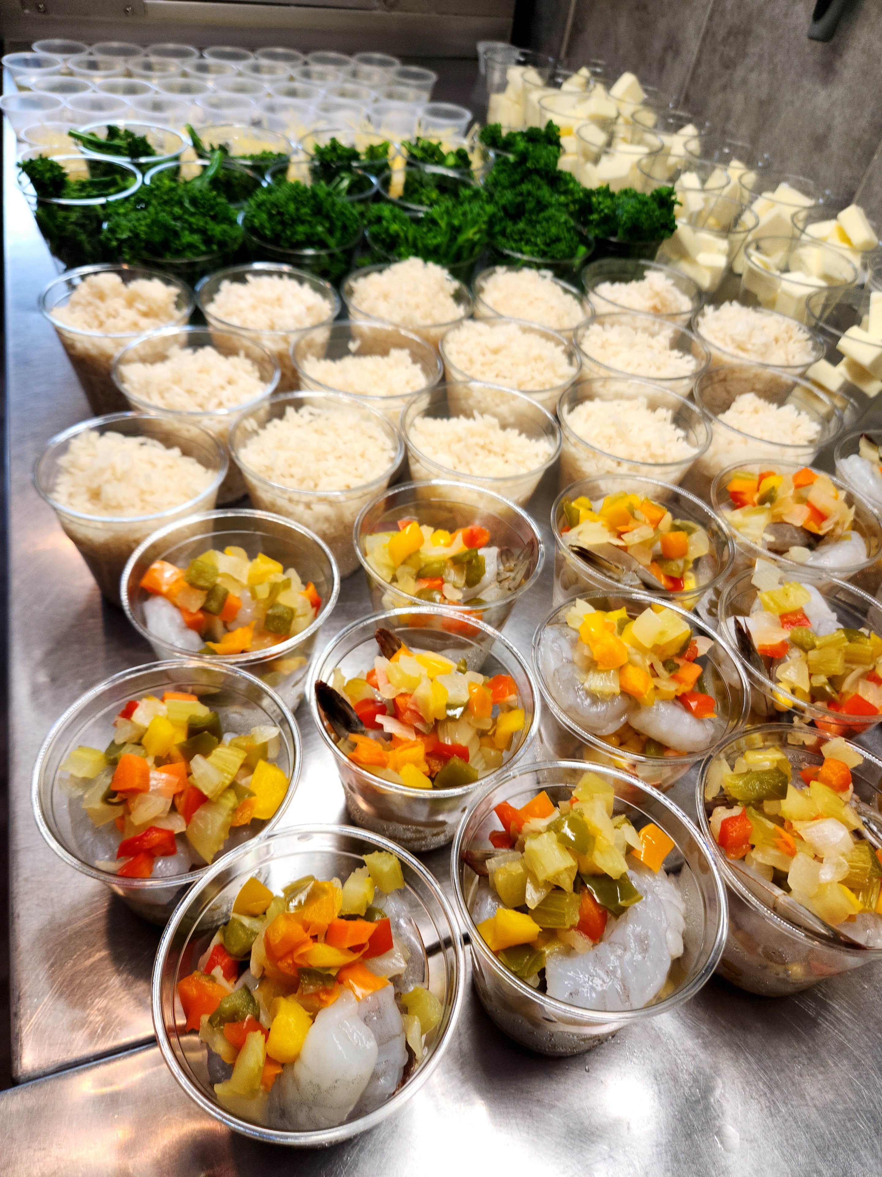 Rows of prepped rice and vegetable salsa cups ready to serve