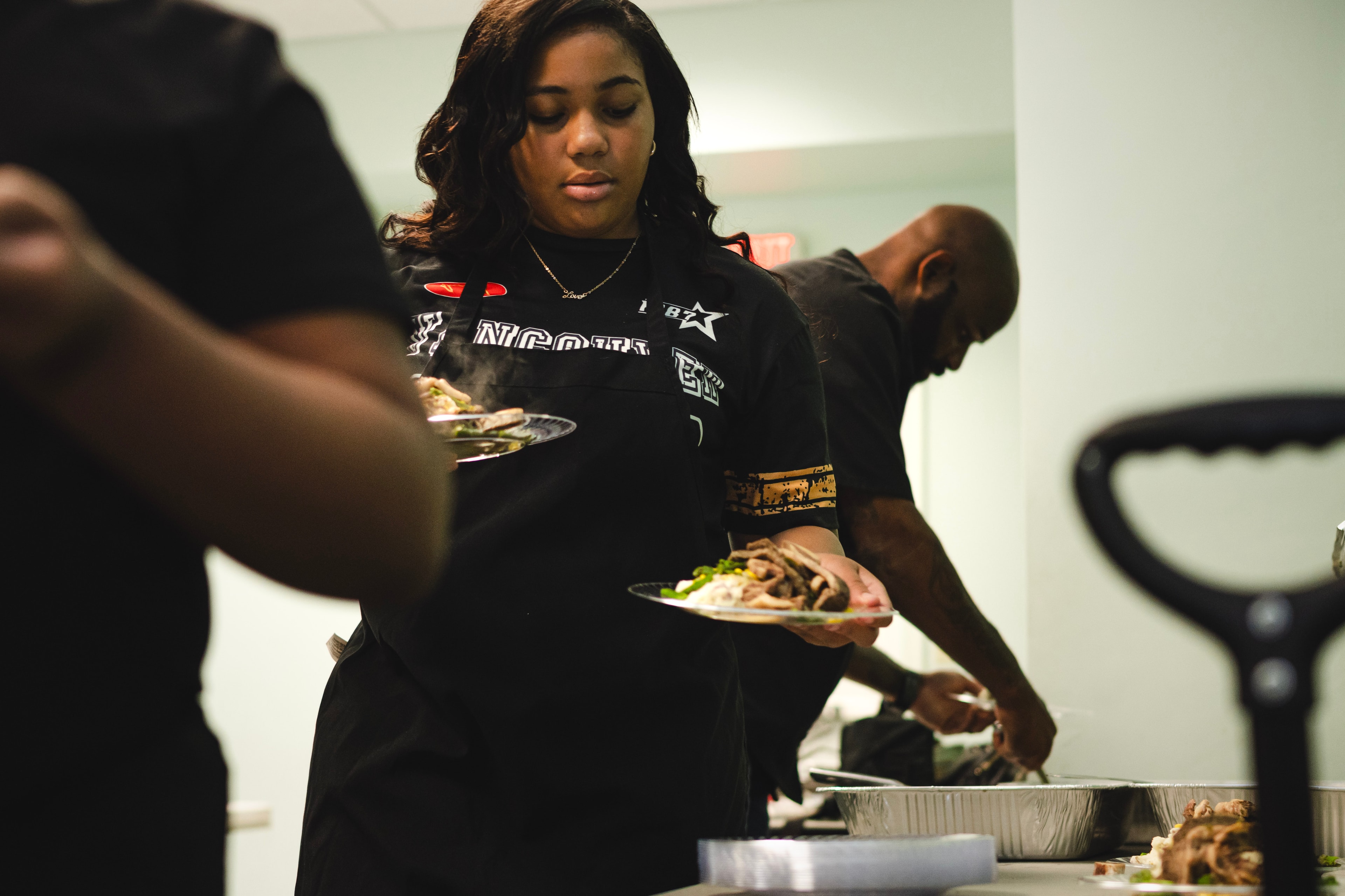 Student serving food at a kitchen event