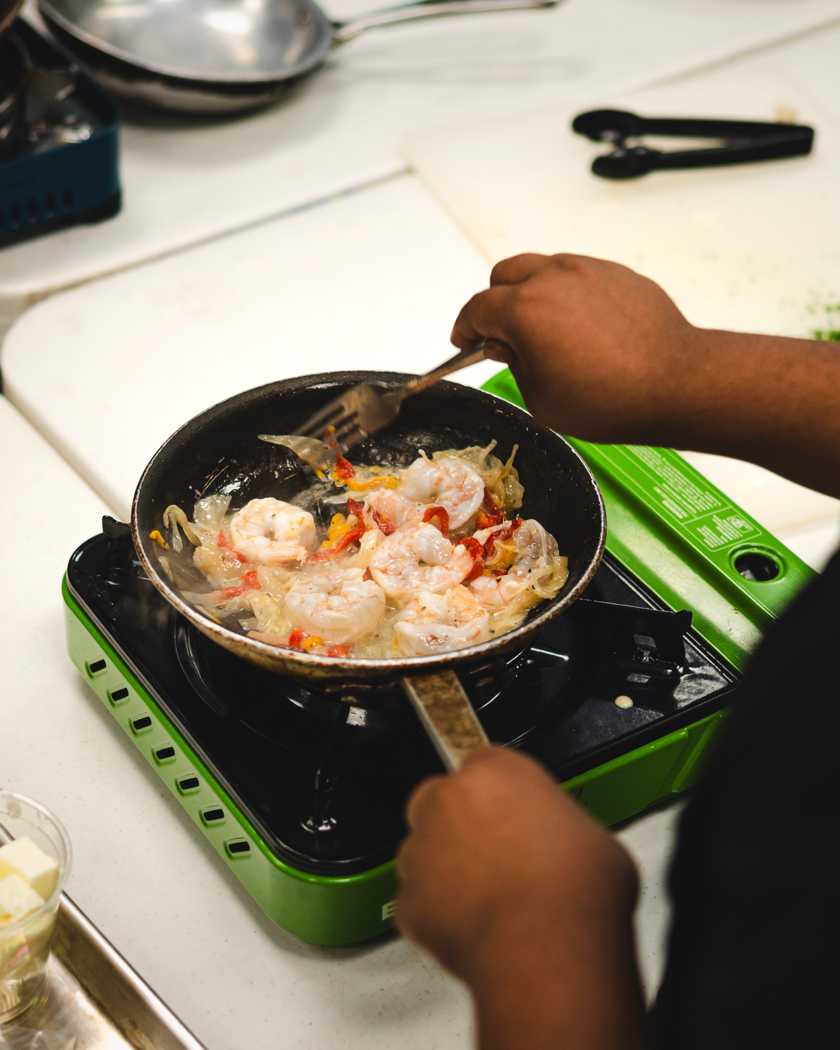 Shrimp cooking in a pan on a portable stove