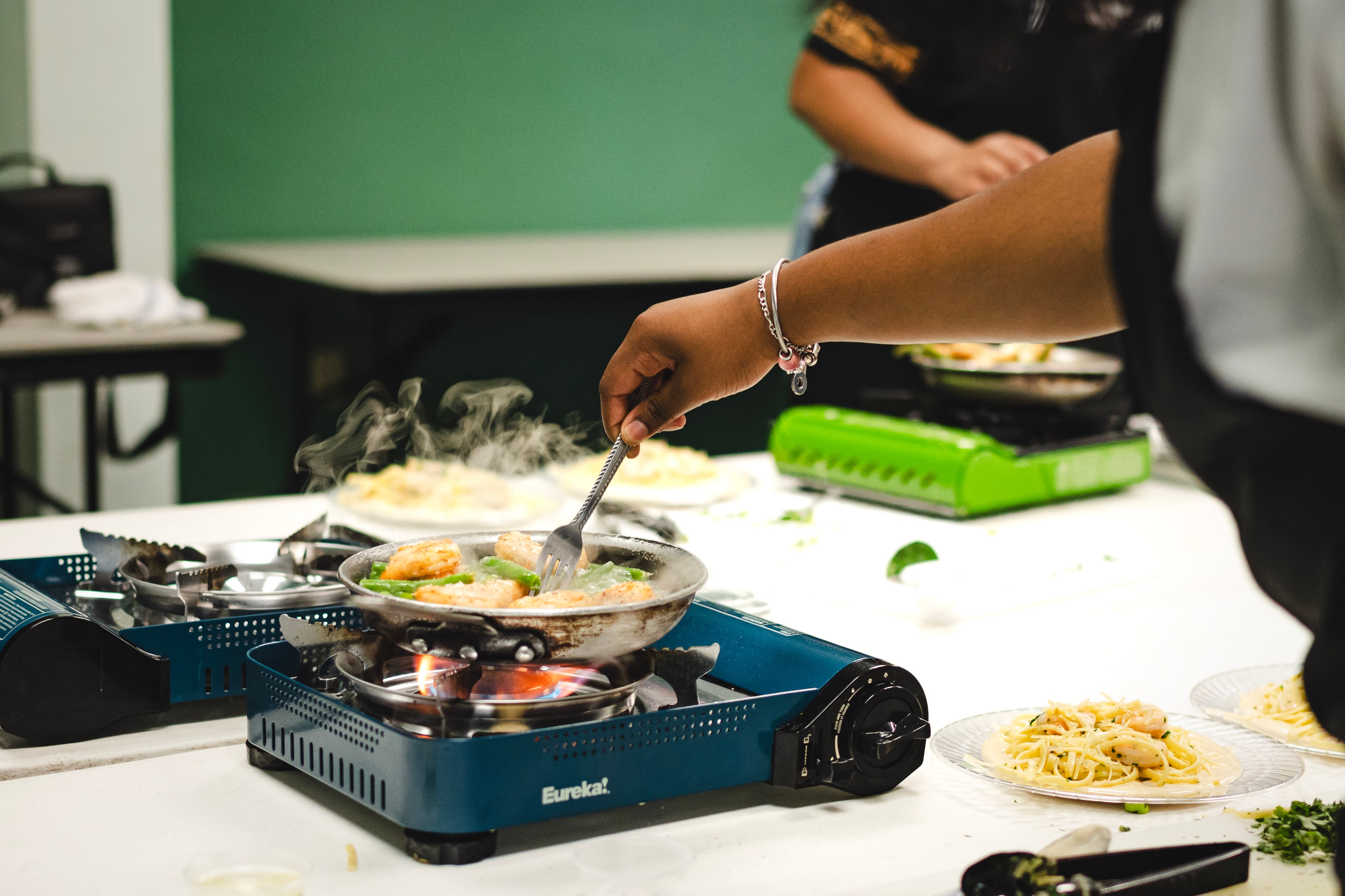 Student cooking scallops on a portable stove