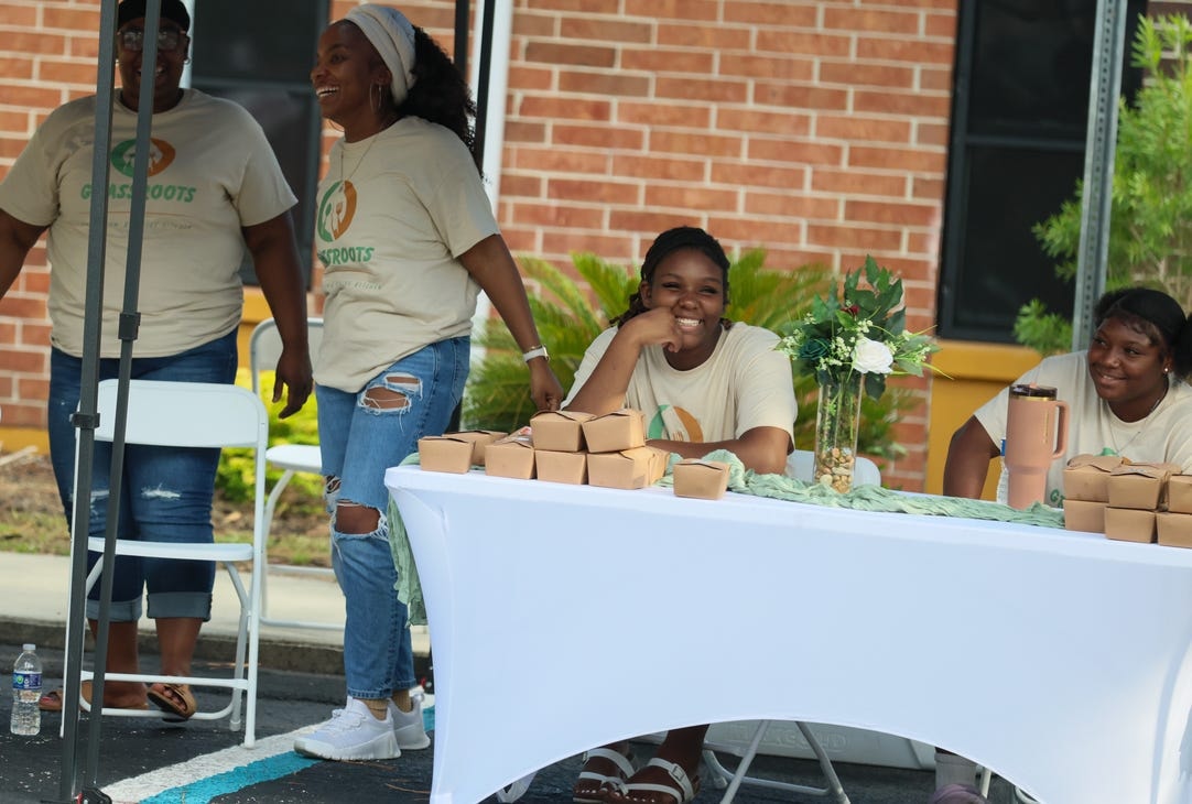 Grassroots volunteers smiling at the meal distribution table