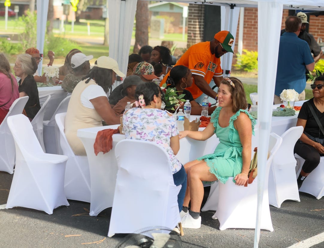 Community members seated under a tent at a Grassroots dinner event