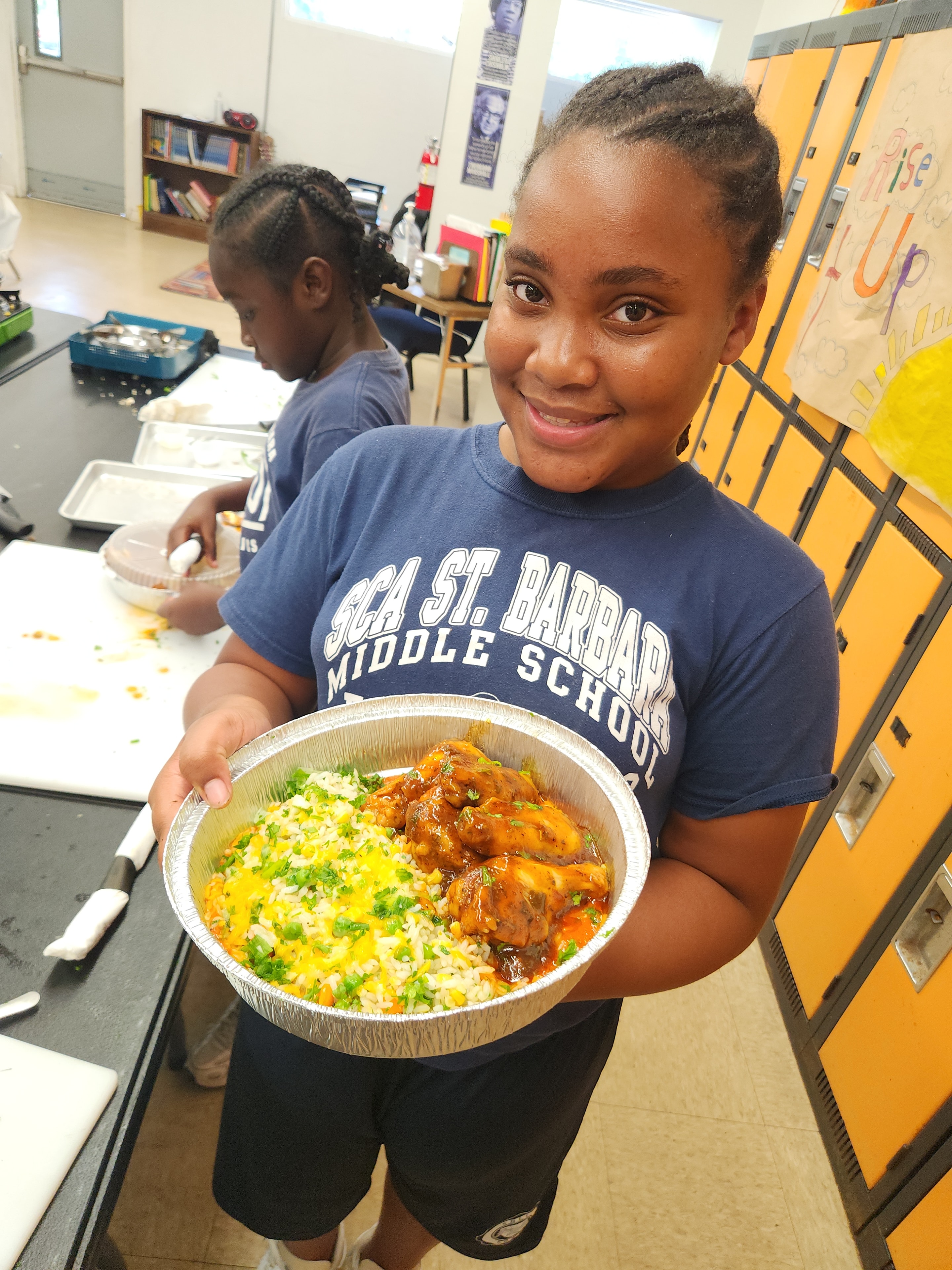 Student holding a chicken and rice dish at school