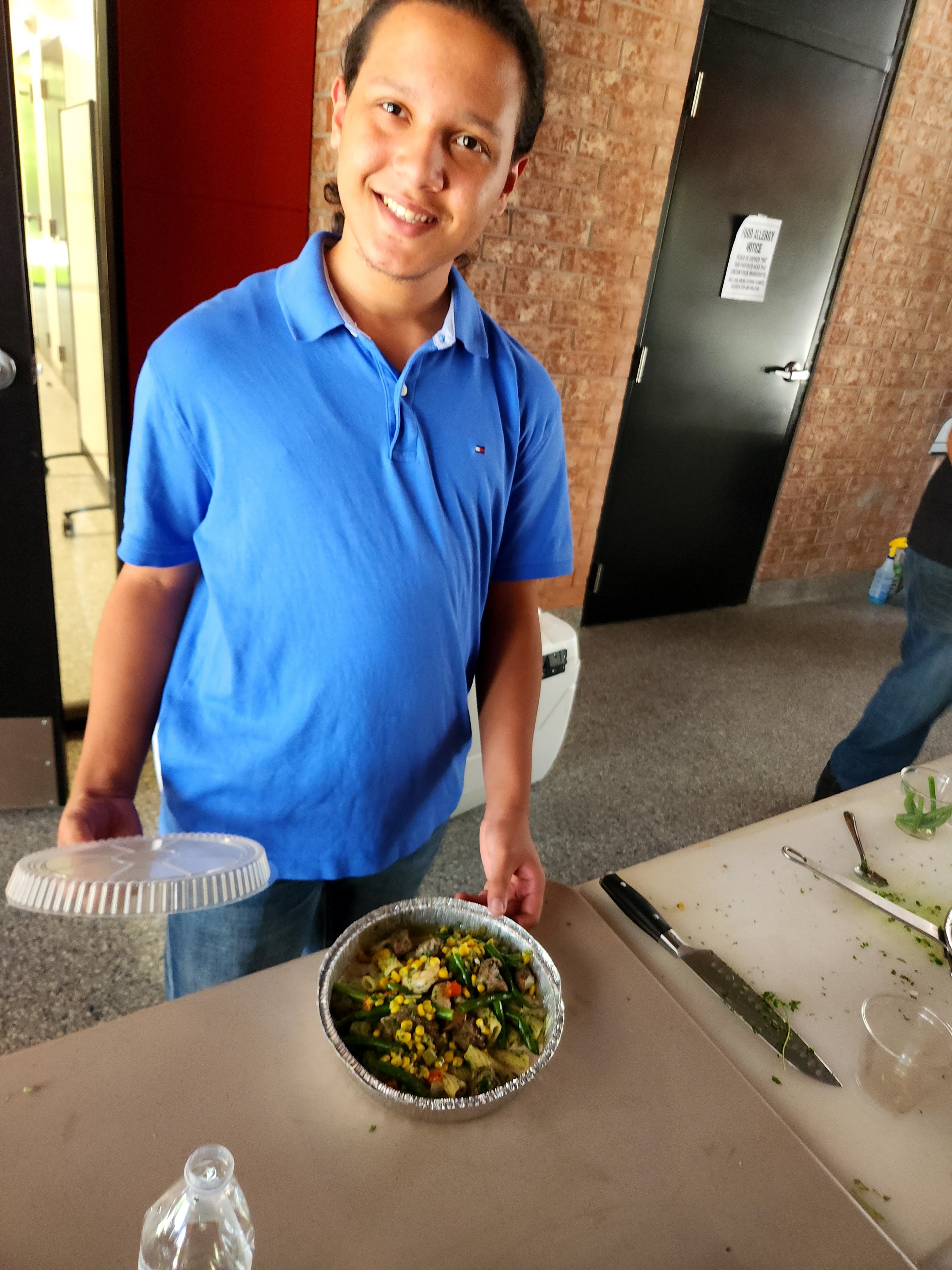 Student proudly holding a finished dish
